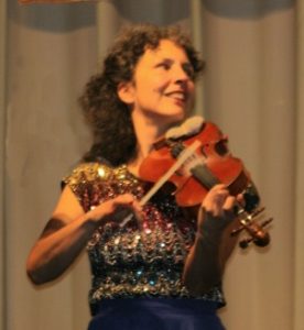 Kitty McIntyre, bluegrass fiddler for Vernon McIntyre's Appalachian Grass, doing her trick fiddle act. She is playing the fiddle with a chopstick.