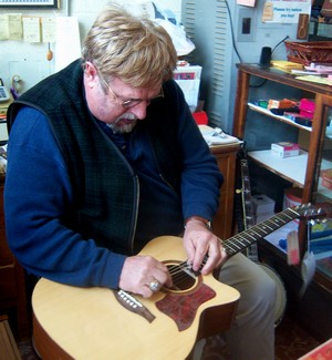 Vernon McIntyre, bluegrass musician, doing a guitar repair