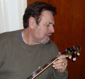 Vernon McIntyre, a well-known bluegrass musician, appraising a banjo