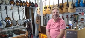 picture of Vernon McIntyre in his newly opened string instrument shop called Famous Old Time Music Company in Millville, OH